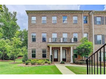 Charming brick townhome with well-maintained landscaping and inviting entrance at 711 Topsail Ln, Alpharetta, GA 30005
