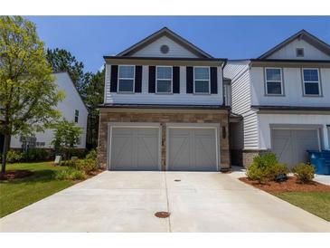Two-story townhome featuring a stone veneer, double garage and manicured landscaping at 4098 Haleston Rd, Duluth, GA 30097