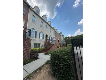 Charming townhome with brick accents, landscaped front, and inviting stairs to the front entrance at 6459 Chariot St # 35, Atlanta, GA 30328