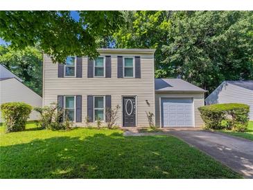 Charming two-story home with a well-manicured lawn and an attached one-car garage at 1377 Mill Lake Cir, Stone Mountain, GA 30088