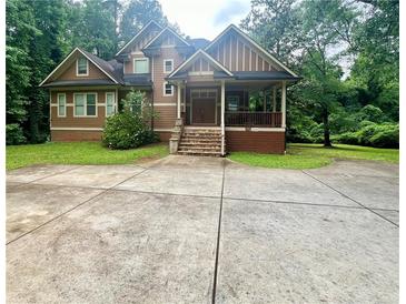 Charming two-story home with a welcoming front porch and well-manicured lawn surrounded by lush trees at 2961 River Ridge Drive Sw, Atlanta, GA 30354