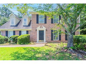 Charming brick home featuring black shutters and a well-manicured front yard at 1797 Emerson Lake Cir, Snellville, GA 30078