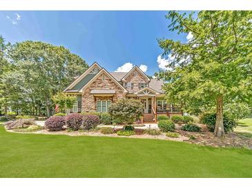 Charming stone home featuring a beautifully landscaped front yard with lush greenery and mature trees at 2010 Bennett Rd, Grayson, GA 30017