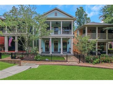 Charming two-story home featuring a double front porch and a well-manicured lawn with black metal fence at 659 Holcomb Bridge Rd, Norcross, GA 30071