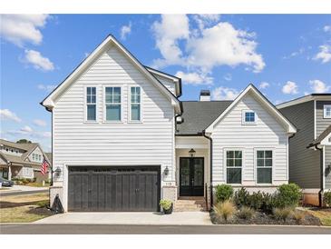 Charming two-story home featuring a black garage door, brick accents, and inviting front entrance at 115 Ivey Way, Woodstock, GA 30188