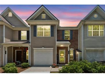 Charming two-story townhouse with a well-manicured front yard at sunset at 299 Azalea Cir, Cumming, GA 30040