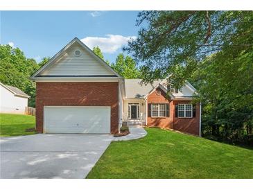 Charming single-Gathering home featuring a brick facade, two-car garage, and well-manicured lawn at 384 Daniel Mill Xing, Villa Rica, GA 30180