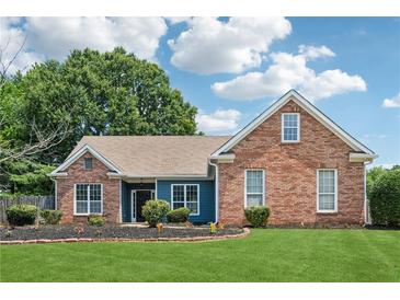Charming brick home with manicured lawn and garden beds, showcasing curb appeal and a welcoming facade at 4369 Milford Pl, Hoschton, GA 30548