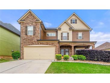 Charming two-story home featuring a stone facade, two-car garage, and well-manicured lawn, inviting curb appeal at 3755 Lake Haven Way, Atlanta, GA 30349