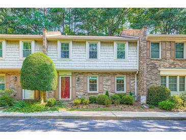 Charming townhouse with shake siding, brick accents, a well-manicured lawn, and a vibrant red front door at 3440 Ashwood Ln, Atlanta, GA 30341