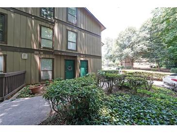 Charming two-story condo with lush landscaping and inviting green doors and walkways at 3907 Cedar Cir, Tucker, GA 30084