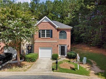 Charming two-story townhome with brick facade, attached garage, and beautifully landscaped front yard at 4221 Rogers Creek Ct, Duluth, GA 30096
