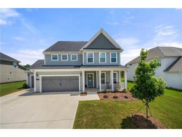 Beautiful two-story home featuring a well-manicured lawn, gray siding, and an attached two-car garage at 916 Gambino Trce, Peachtree City, GA 30269