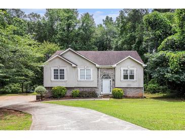 Charming one-story home featuring a well-manicured lawn, mature trees, and a welcoming front entrance at 3514 Blackberry Se Ln, Conyers, GA 30094