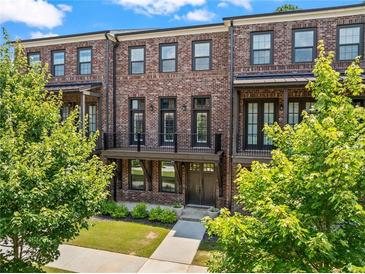 Charming brick townhome with a covered porch and landscaped front yard at 775 Hadley Ne Ln, Marietta, GA 30068