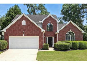 Charming two-story brick home with manicured lawn and attached two-car garage at 200 Ennisbrook Se Dr, Smyrna, GA 30082
