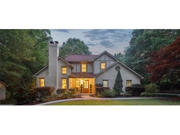 Charming two-story home with brick chimney, lush landscaping and manicured front yard at 205 Pine Lake Dr, Cumming, GA 30040