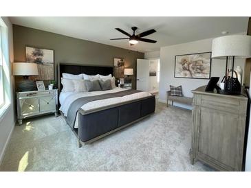Beautifully staged bedroom with a modern ceiling fan and decorative side tables and complementary furniture at 120 Winsome Way, Woodstock, GA 30188