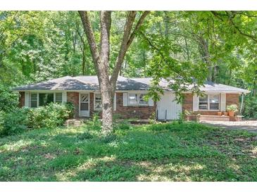 Charming single-story brick home with mature trees and a spacious front yard at 8587 Cumming Se Hwy, Canton, GA 30115