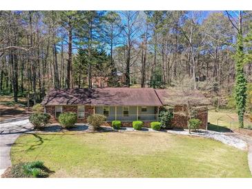 Charming brick home featuring a well-manicured lawn and beautiful landscaping at 9491 Hidden Branch Dr, Jonesboro, GA 30236