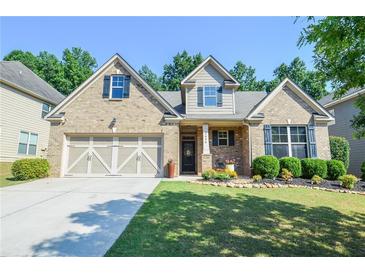 Charming brick home featuring a manicured lawn, a two-car garage, and lovely landscaping at 2436 Loughridge Dr, Buford, GA 30519