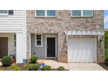 Charming townhouse featuring a black front door, attached garage and manicured front yard at 161 Swindon Dr, Mcdonough, GA 30253