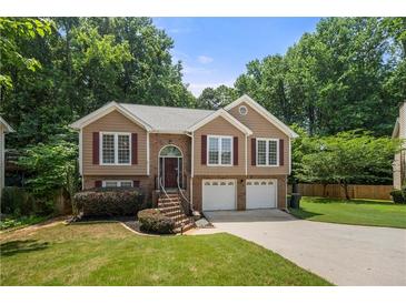 Charming split-level home with brick accents, attached two-car garage, and a well-manicured lawn at 2775 Harper Ferry Dr, Lawrenceville, GA 30044