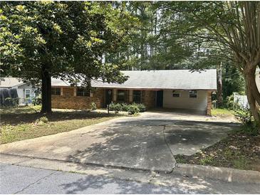 Cozy single-story brick house with a long driveway and mature trees at 4595 Sahara Sw Dr, Atlanta, GA 30331