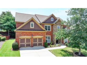 Beautiful two-story home featuring brick and stone accents, well-manicured lawn, and a two-car garage at 5485 Sandstone Ct, Cumming, GA 30040