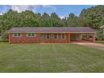 Charming red brick home with covered carport and beautifully manicured lawn at 4601 Lindsey Dr, Powder Springs, GA 30127