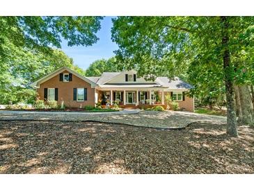 Charming brick home with a cozy front porch and beautiful landscaping, perfect for relaxing outdoors at 401 Riverwalk, Mcdonough, GA 30252