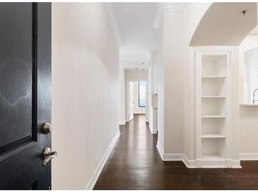 Bright hallway boasts hardwood floors and built-in shelving, leading to an airy living space at 3445 Stratford Ne Rd # 3403, Atlanta, GA 30326