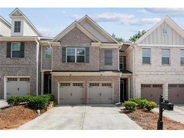Charming brick townhome with a two-car garage and meticulously manicured landscaping at 1982 Brightleaf Way, Marietta, GA 30060