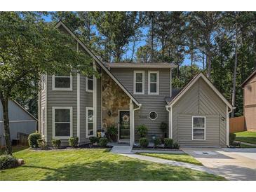 Charming two-story home featuring a stone accent facade, well-manicured lawn, and a cozy, inviting entrance at 5086 N Woodbridge Trl, Stone Mountain, GA 30088