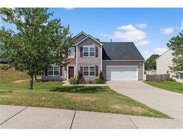 Charming two-story home featuring a well-manicured lawn, gray siding, and a two-car garage on a sunny day at 1644 Royal Ives Dr, Lawrenceville, GA 30045