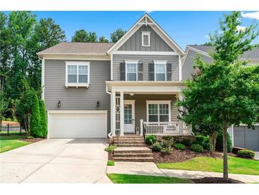 Charming two-story home with gray siding, white trim, front porch, attached two-car garage, and nicely landscaped front yard at 310 Braeden Way, Alpharetta, GA 30009