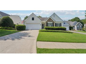 Charming one-story home with a manicured lawn, two-car garage, and stone detailing at 6755 Waveland Dr, Cumming, GA 30040