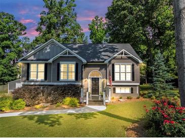 Charming two-story home with well-maintained lawn, colorful flowerbeds, and mature trees at 70 Maplewood Ln, Acworth, GA 30101
