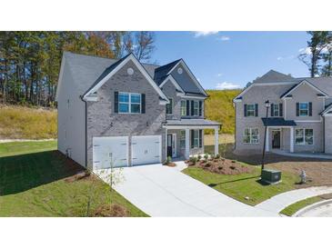 Charming two-story home with a gray brick facade, two-car garage, and neatly landscaped front yard at 1821 Lacebark Elm Way, Lawrenceville, GA 30045