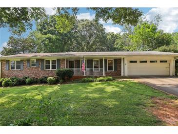 Charming brick ranch home with a well-maintained lawn and an attached garage at 5623 Crestwood Dr, Stone Mountain, GA 30087