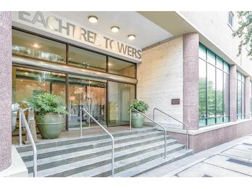 Building entrance featuring large windows and glass doors and stone stairs at 300 Peachtree St # Apt 9D, Atlanta, GA 30308