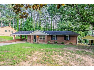 Charming brick ranch home with a cozy carport and traditional curb appeal surrounded by mature trees at 4748 Carson Sw Pass, Atlanta, GA 30331