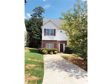 Charming two-story home features a brick and siding facade, complemented by well-maintained landscaping and a paved driveway at 301 Brookview Dr, Riverdale, GA 30274