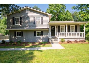 Charming two-story home with gray siding, black shutters, a covered front porch, and landscaped yard at 2880 Brett Nw Cir, Acworth, GA 30101