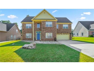 Charming two-story brick home with a lush green lawn and a welcoming blue front door at 85 Shiver Blvd, Covington, GA 30016