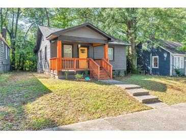 Charming home with a covered front porch, gray siding and a bright yellow front door at 1336 Mcclelland Ave, Atlanta, GA 30344
