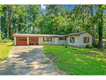 Ranch style home with attached two-car garage and mature trees surrounding at 4235 Apache Se Dr, Acworth, GA 30102