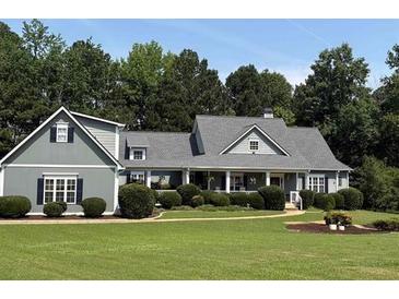 Charming one-story home with gray siding, a lovely front porch, and beautifully landscaped front yard at 200 Chaparral Trce, Tyrone, GA 30290