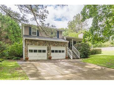 Charming two-story home with a stone facade, a two-car garage, and a well-manicured lawn at 4411 Westerling Ct, Powder Springs, GA 30127