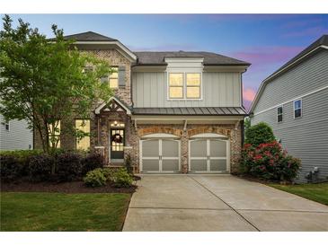 Charming brick and siding two-story home with a two-car garage and beautiful landscaping at 935 Grove Valley Drive Dr, Cumming, GA 30041